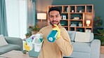 Happy young man in rubber gloves having fun house cleaning. Guy acting in a cleaning commercial, laughing, smiling with clean equipment. Male at home celebrating his victory of cleaning the area.