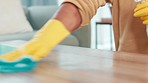 man wiping a table at home. Closeup of a male sanitizing and spring cleaning a table surface with a cloth. Busy with routine housework and chores for a neat, hygienic and germ free living space