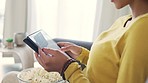 Woman shopping online with a digital tablet and and credit card at home. Closeup of a consumer entering banking details to process a secure internet payment while spending money on deals and bargains