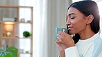 Young woman drinking a hot cup of tea or coffee at home with copy space. One beautiful female smelling the aroma of a fresh warm beverage while relaxing at home. Enjoying a comfortable an cozy break
