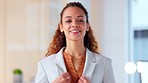 Portrait of a young beautiful woman looking proud and confident while standing in an office at work. One gorgeous, elegant and smiling business woman standing with arms crossed at a startup company