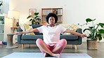 Afro woman doing yoga greeting gesture or meditation. One calm and spiritual female feeling peaceful while practicing Anjali mudra, namaste, prayer hands with palms together inside a living room