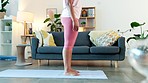 Young woman doing yoga exercises at home. Girl doing downward facing pose on a mat while practicing mediation mind, body and inner peace. Active person stretching muscles to improve flexibility