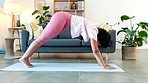 Yoga woman stretching in downward facing dog and upward facing dog pose to aid mobility in her back, spine and muscles in home zen class. Serene yogi finding mental balance in holistic body exercise