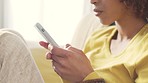 Closeup of woman's hands texting on phone while sitting on a couch at home. Zoom in on a female chatting online or researching on the internet while relaxing on a sofa. Lady replying to text message