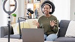 Cool afro journalist using digital tablet, talking into microphone and hosting podcast or broadcasting news while wearing headphones. Excited young woman using technology to promote on air from home