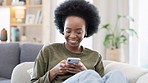 Young woman smiling and laughing while texting on a phone at home. Cheerful female chatting to her friends with apps, scrolling social media and watching funny internet memes while relaxing on a sofa