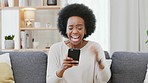 Shocked woman shouting and cheering with joy while reading an email with good news alone on the couch at home. Surprised and cheerful black female shouting excitedly after getting back test results