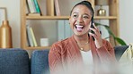 Young female on a phone call doing remote freelance work.  Happy woman talking to family or a friend, receiving good news. African American lady having a casual conversation, sitting on a couch.