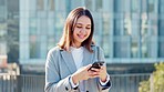 Portrait of a female designer texting on a phone and browsing online while standing in the city alone. Young, happy and smiling woman searching the internet for a gps location while commuting to work