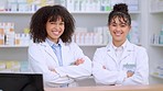 Portrait of two pharmacists with arms crossed in a pharmacy ready to dispense over the counter prescription medication. Happy young professional healthcare workers smiling and selling medicine