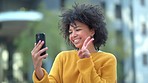 Fun afro student taking selfies on phone for social media and making happy memory in city. Cool, funky and fashionable woman showing peace sign gesture and symbol, blowing kisses and streaming online