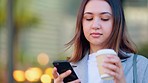 Businesswoman checking messages during her coffee break outdoors. Young corporate woman texting and checking emails online outside, then smiling after receiving good feedback from one of her clients