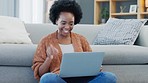 Happy African American woman using laptop and waving on a video call in a living room. Young black female having a casual chat with friends at home. Lady excited to talk to her family during lockdown