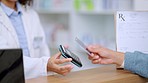 Closeup customer hands using ebanking credit card to pay on contactless nfc machine to collect prescription medication from pharmacist. Man tapping or scanning electronic device for pharmacy medicine