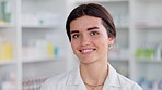 Portrait of a happy pharmacist working in a pharmacy. Young female healthcare worker smiling and laughing. Ready to offer good service and expert advice when dispensing medication in a drugstore