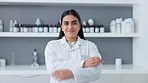 Phd scientist standing with arms crossed in a lab. Portrait of a happy indian woman working as a medical pathologist and clinical researcher feeling confident about her tests for a successful cure