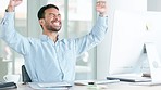 Business man cheering with joy while working on a computer in an office. Successful and lucky trader celebrating victory with a happy dance after reading good news about an exciting deal or bonus