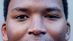 Closeup portrait of a confident black man blinking in slow motion. Young African American male staring blankly ahead, focused and inspired to move forward. Ambitious guy thinking of future plans 