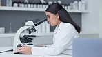 Laboratory scientist looking into a microscope to examine a sample on a slide. Biochemist engineer searching for breakthrough virus cure through medical research and writing discovery on clipboard