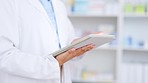 Doctor holding a digital tablet and browsing the internet online doing research on medical illnesses at a hospital. One professional healthcare worker searching the web and checking their schedule