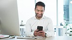 Man laughing while typing and sending texts to his friends and working in an office alone. Young businessman smiling and looking cheerful while browsing social media online and chatting to loved ones