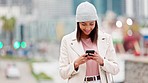 Woman laughing while reading a funny text on her phone on a cold day in the urban city. Trendy and cheerful female sending a message or using a mobile app to book a cab or taxi while traveling