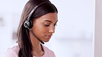 Call centre agent wearing headset and assisting with online enquiry for customer support service. Portrait of young sales representative smiling while making a sale at her helpdesk in the office