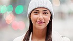 Trendy young woman in winter wearing stylish beanie in a city with bokeh background. Beautiful, confident and cheerful female with carefree and cool attitude smiling and laughing while exploring town