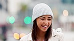 Happy girl laughing and looking joyful with bokeh lights in winter. Portrait of a cute young woman smiling, enjoying a walk outside on a cold morning in the city against a blurred urban background