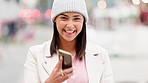 Green screen, trendy woman sending a message on her phone while standing on a city street on a cold day. Cheerful female browsing the internet and showing cool mobile app or website while traveling