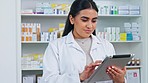 Pharmacy technology, portrait of a friendly pharmacist typing on a digital tablet to update stock system and inventory. Face of a qualified woman checking online prescriptions on mobile pharma app