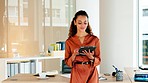 Cheerful, smiling and happy latino business woman browsing on a digital tablet in a modern office. Portrait of confident entrepreneur feeling ambitious and motivated for success while planning online