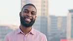 A confident male student standing outdoors in the city with copy space. A young stylish black entrepreneur feeling happy with a bright smile. An American business man smiling outside an urban town