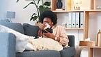 Sick afro woman streaming on phone while coughing, suffering from covid fatigue and blowing her nose with tissue. Young woman watching movies on technology and ill with sinuses, cold or flu allergies