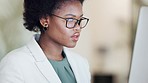 Black business woman researching online tools and courses to improve office management skills. Young ambitious African American worker searching internet for solution while thinking about her future
