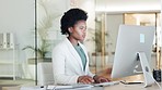 Portrait of a serious black business woman looking focused while working on computer in a modern office. Confident young professional feeling ambitious and motivated for success in a startup company