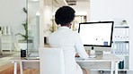 Stressed business woman suffering from fatigue while sitting at her desk in an office. Rearview of an african female massaging her neck while feeling frustrated, struggling to reach a deadline