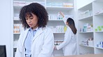 Two pharmacists talking and working together in a pharmacy. Female manager working on computer and giving colleague advice on medication in a drugstore. Female chemists working behind a counter