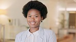 Portrait of the face of a cheerful lawyer smiling and laughing while standing alone in an office at work. Headshot of one confident and happy black female advocate working at a legal company