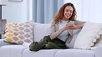 Young woman texting on social media, surfing the internet with her smartphone. Portrait of a cheerful, trendy and edgy female sitting or relaxing on a sofa shopping online on a mobile app at home