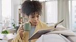 Curious woman reading story book, drinking coffee and enjoying relaxing day off in home living room. Young student studying or author interested in fairytale, fiction novel and sipping on mug of tea