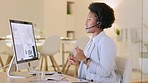 Call center agent talking to clients while wearing a headset and working on a desktop computer in an office. Young black female customer service worker giving advice and helping people with questions