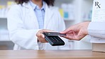 Customer paying with card for prescription medicine in a pharmacy. Female pharmacist using a card machine while client makes payment at pos checkout counter while buying medication at local drugstore