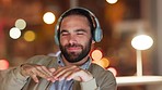 A carefree, goofy male enjoying to his favorite song or artist, using headphones. A Caucasian man laughing while listening to music in a coffee shop. A smiling white guy dancing to a beat or rhythm.