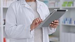 Closeup of pharmacist searching on a digital tablet and checking pharmacy prescription drug, pill or antibiotic stock. Medical professional browsing and researching painkiller medicine on technology