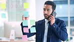 Male office worker writing creative business ideas on a call. Marketing manager working and talking on the phone and writing on colorful notes. Corporate leader planning a teamwork meeting.