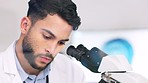 Laboratory scientist using microscope to examine monkeypox virus and note his discovery. Closeup of serious biochemist engineer doing medical research with scientific equipment for breakthrough cure