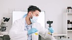 Scientist and research or medical engineer doing experiments to create a cure in a lab while wearing a mask. Healthcare professional working with science equipment and writing notes in a laboratory