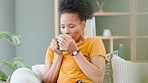 Carefree, relaxed and comfortable woman enjoying a cup of tea, coffee or warm drink in the lounge at home. One cozy, easygoing and satisfied female taking a break to sip on a fresh hot beverage
